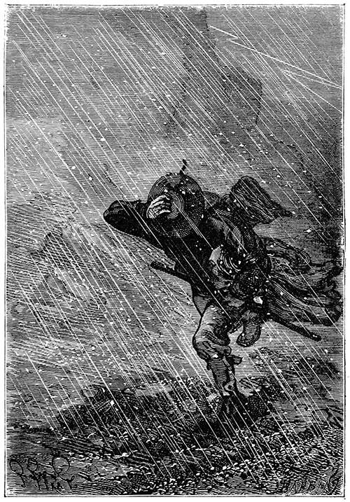 A man wearing a hat walks against the wind in a hail storm